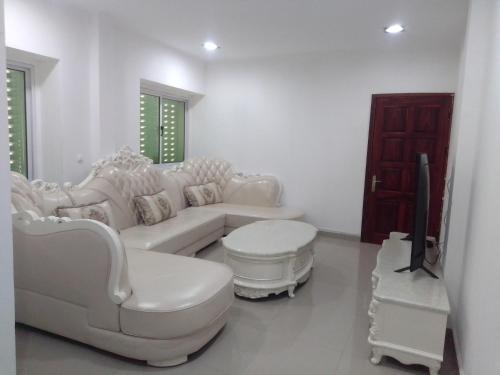 BenguelaにあるResidencial beira mar Benguelaのリビングルーム(白いソファ、テレビ付)