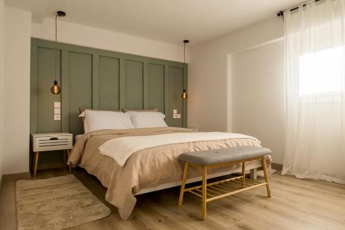 een slaapkamer met een groot bed met een groen hoofdeinde bij Thalpo home in Ioannina