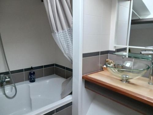 a bathroom with a sink and a bath tub with a glass bowl at Chez Barnar in Arvert