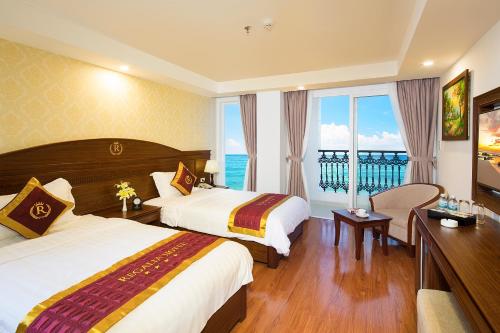 a hotel room with two beds and a balcony at Regalia Nha Trang in Nha Trang