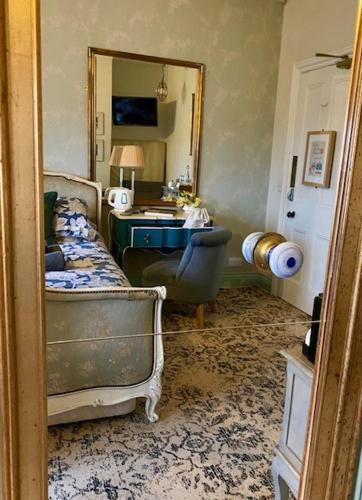 ein Schlafzimmer mit einem Bett, einem Schreibtisch und einem Spiegel in der Unterkunft The Poplars Boutique BB in Lincoln