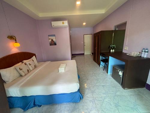 a bedroom with a large bed and a desk at Weixiao Lanta Resort in Ko Lanta