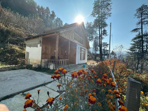 ein Haus mit Blumen davor in der Unterkunft Himalayan Mountain View Cottage Deohari in Sainj