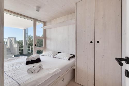 a bedroom with a bed and a large window at Pupsi Garden Villa in Drage