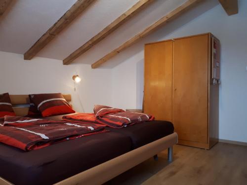 FlumserbergにあるFerienwohnung Tschudibodenのベッドルーム1室(ベッド1台付)、木製キャビネットが備わります。