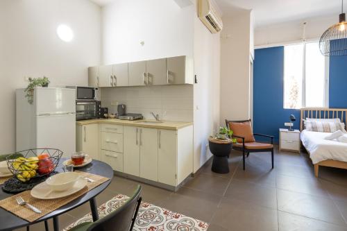 a kitchen and living room with a table and chairs at The Printhouse - Downtown Boutique Apartments by Sea N' Rent in Haifa