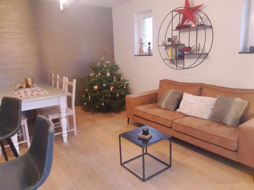 a living room with a christmas tree and a couch at B&B Caprice d'Epices in Francorchamps