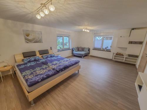 1 dormitorio con 1 cama y 1 silla en Ferienwohnung "Urlaub bei Lina", en Hergatz