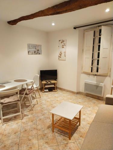 een woonkamer met een tafel en stoelen en een bank bij studio dans le village de cotignac in Cotignac
