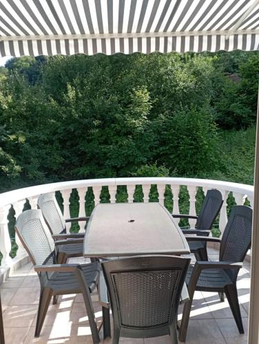 a patio with chairs and a table on a deck at Apartmaji in sobe Kocjančič in Podčetrtek
