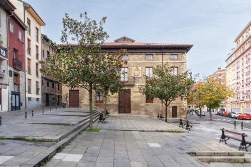 an empty street with benches in front of a building at limehome Vitoria Palacio de los Álava-Velasco in Vitoria-Gasteiz