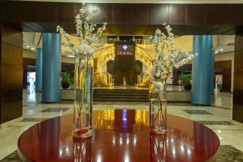 two vases with flowers sitting on a table in a lobby at Jewel Sport City and Aqua Park in Cairo