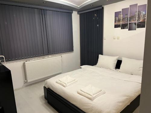 1 dormitorio con 1 cama con sábanas y almohadas blancas en Apartament Kamarashki, en Troyan