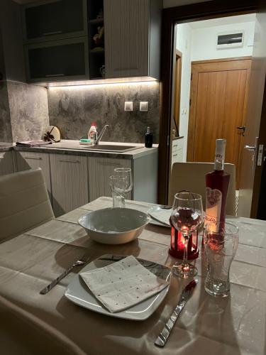 una mesa con un tazón y platos y vasos. en Apartament Kamarashki, en Troyan