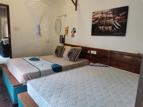 1 dormitorio con 2 camas y una foto en la pared en A B C Hotel en Udawalawe