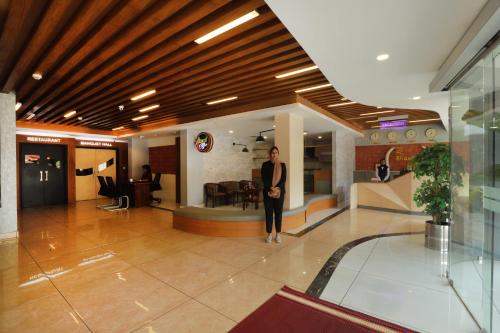 a woman standing in a lobby of a building at Bhavanam Regency Guruvayoor in Guruvāyūr