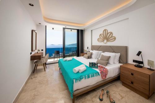 a bedroom with a large bed and a desk with a desk at Villa Eos - Kalkan Villa in Kaş