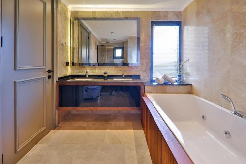 a bathroom with a tub and a sink and a mirror at Villa Eos - Kalkan Villa in Kaş