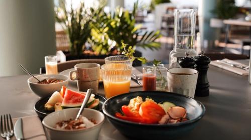 a table with bowls of food and orange juice at Quality Hotel Arlanda XPO in Arlanda