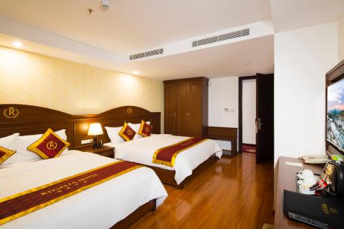 a hotel room with two beds and a television at Regalia Nha Trang in Nha Trang