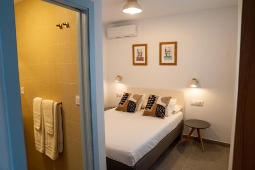 a small bedroom with a bed and a shower at Hostal Tarantelo Conil in Conil de la Frontera