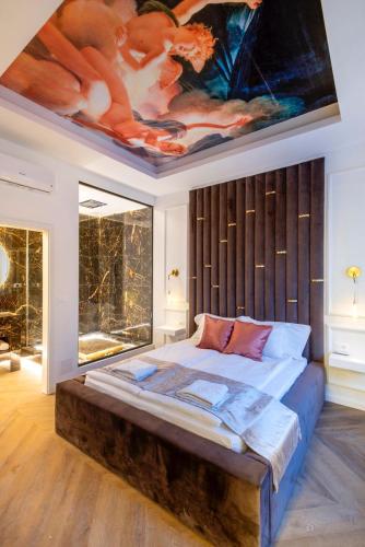 a bedroom with a large bed with a painting on the ceiling at TOP Luxury Suites in Budapest