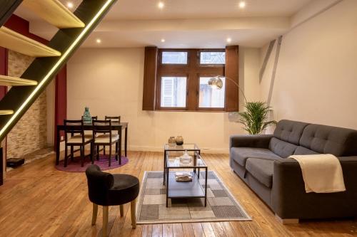 a living room with a couch and a table at Chouet'appart in Dijon