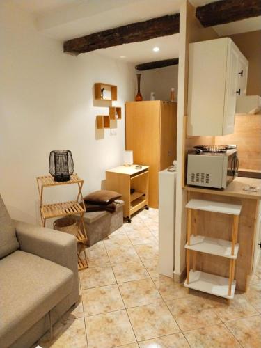 ein Wohnzimmer mit einem Sofa und einer Küche in der Unterkunft studio dans le village de cotignac in Cotignac