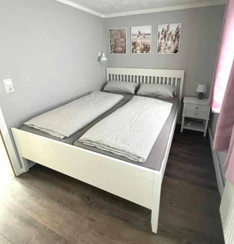 a bed in a bedroom with a white bed frame at Boddenferienhaus - 12 Molenfeuer in Schaprode