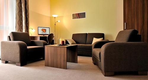 a living room with two couches and a table at Melrose Apartments in Bratislava