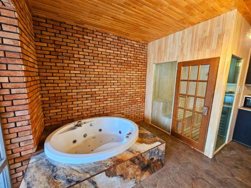 a bathroom with a large tub in a brick wall at Trigon Villa Family , HOT POOL ,SAUNA,JACUZZI in Gabala