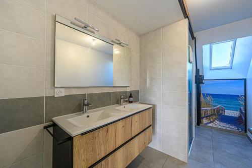 a bathroom with a sink and a mirror and a window at L'Aquagîte - Appt avec terrasse vue mer in Baden