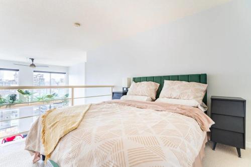 Schlafzimmer mit einem großen Bett mit einem grünen Kopfteil in der Unterkunft loft in downtown Vancouver with free parking in Vancouver