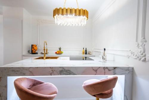 a kitchen with two pink chairs and a sink at TOP Luxury Suites in Budapest