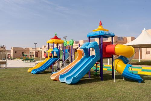 uma fila de escorregas coloridos num parque infantil em Al Bada Hotel and Resort em Al Ain