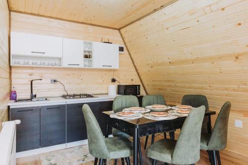 comedor con mesa y sillas y cocina en Cabana A-Frame Sesu, en Cîrlibaba