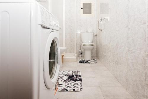 - un lave-linge dans une salle de bains revêtue de noir et blanc dans l'établissement Casa Vacanze Petronia-By Faendho, à Porto Torres