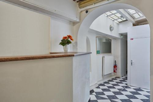 a room with a counter with a vase of flowers at Hotel Petit Vix in Paris