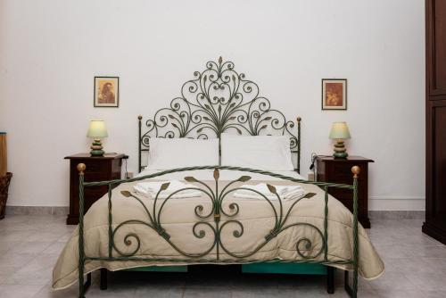 - une chambre avec un lit doté d'une tête de lit en métal dans l'établissement Casa Vacanze Petronia-By Faendho, à Porto Torres