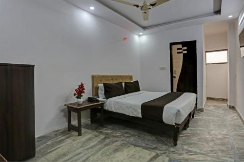 OYO Flagship Blue Moon Residency في نيودلهي: غرفة نوم بسرير كبير وطاولة