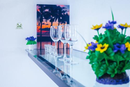 a row of wine glasses on a counter with flowers at The Glade in Weligama