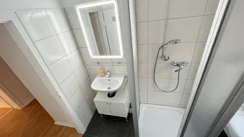 bagno bianco con lavandino e doccia di Work & Stay Apartment with Balcony a Osnabrück