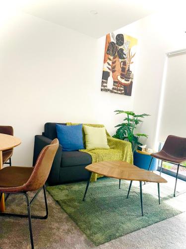 a living room with a couch and a table at Sunny Oasis- Modern Loft Hidden on Cashel in Christchurch