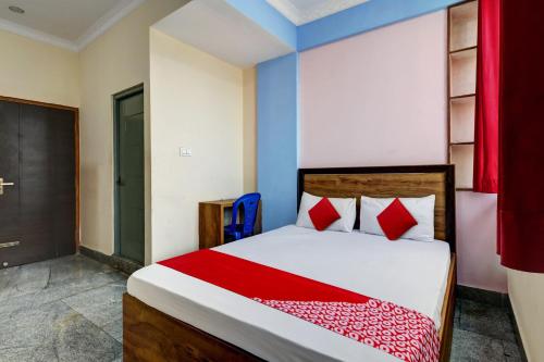 1 dormitorio con 1 cama con almohadas rojas en OYO J.B. BOARDING AND LODGING, en Bangalore