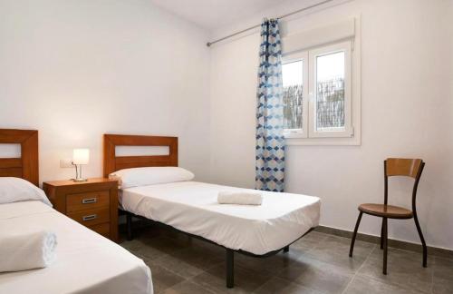 een kamer met 2 bedden, een raam en een stoel bij Villa Montenmedio Juande in El Soto