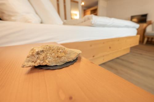 a rock sitting on a table next to a bed at Hotel Sarazena in Zermatt