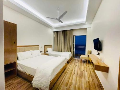 JaliapāraにあるDreamers Paradiseのベッドとテレビが備わるホテルルームです。