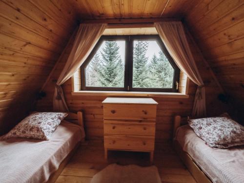 een slaapkamer met 2 bedden en een raam in een hut bij Mountain Cottage Lubomierz in Lubomierz