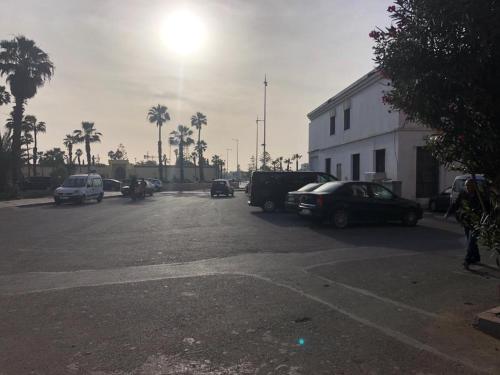 un estacionamiento con autos y un camión estacionado en él en élégant appartement Essaouira, en Essaouira