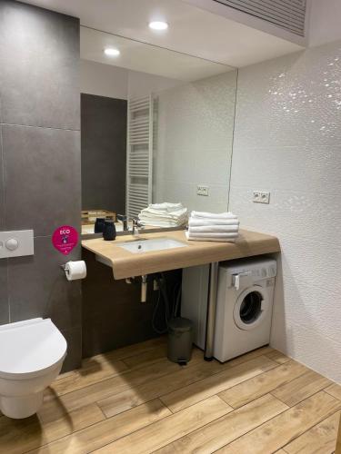 a bathroom with a sink and a washing machine at Apartament przy plaży 9 in Mielno